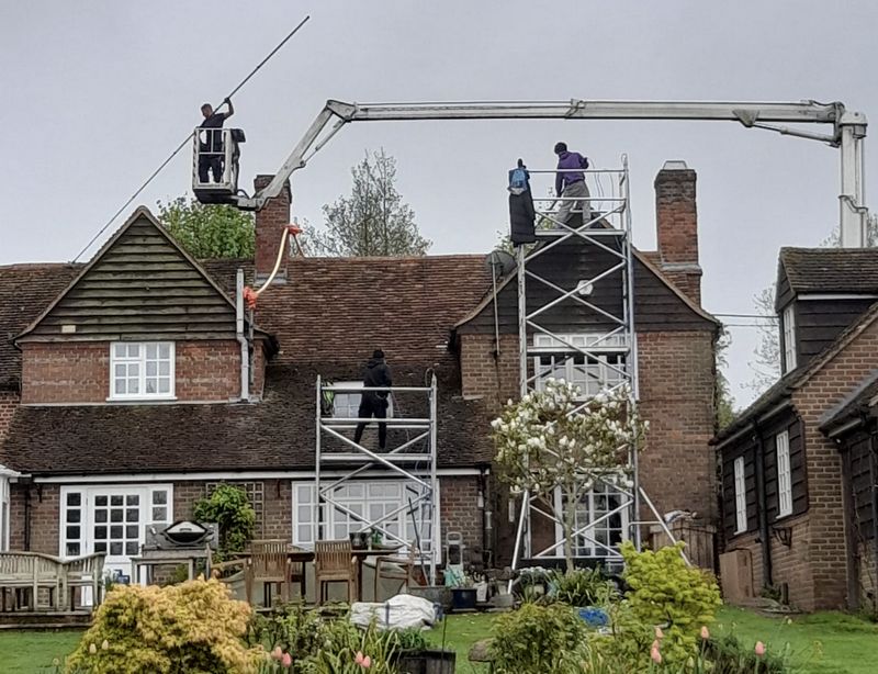 The Moss Cleaners using cherry picker and scaffolding to clean roof safely and professionally in Farnborough, Hampshire